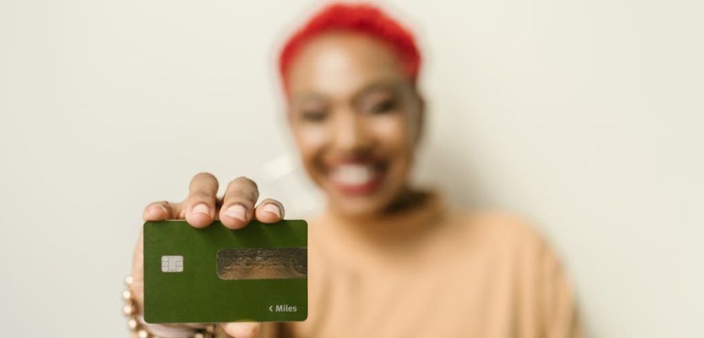 Une personne souriante tenant une carte bancaire verte en avant, illustrant l'engagement individuel et financier dans une démarche conforme à la charte achats responsables.