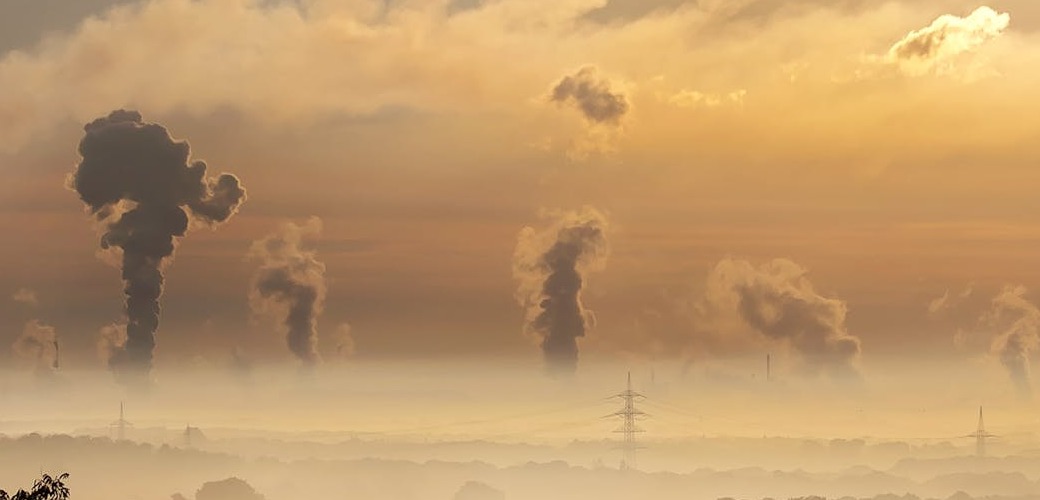 bilan carbone : image représentant un paysage avec des volutes de fumée