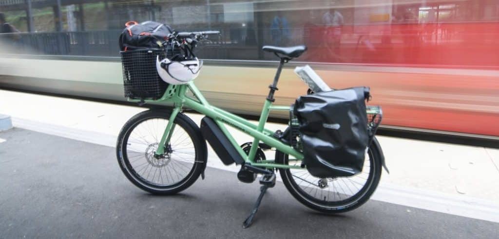 low tech : vélo cargo bleu pale devant un train en marche